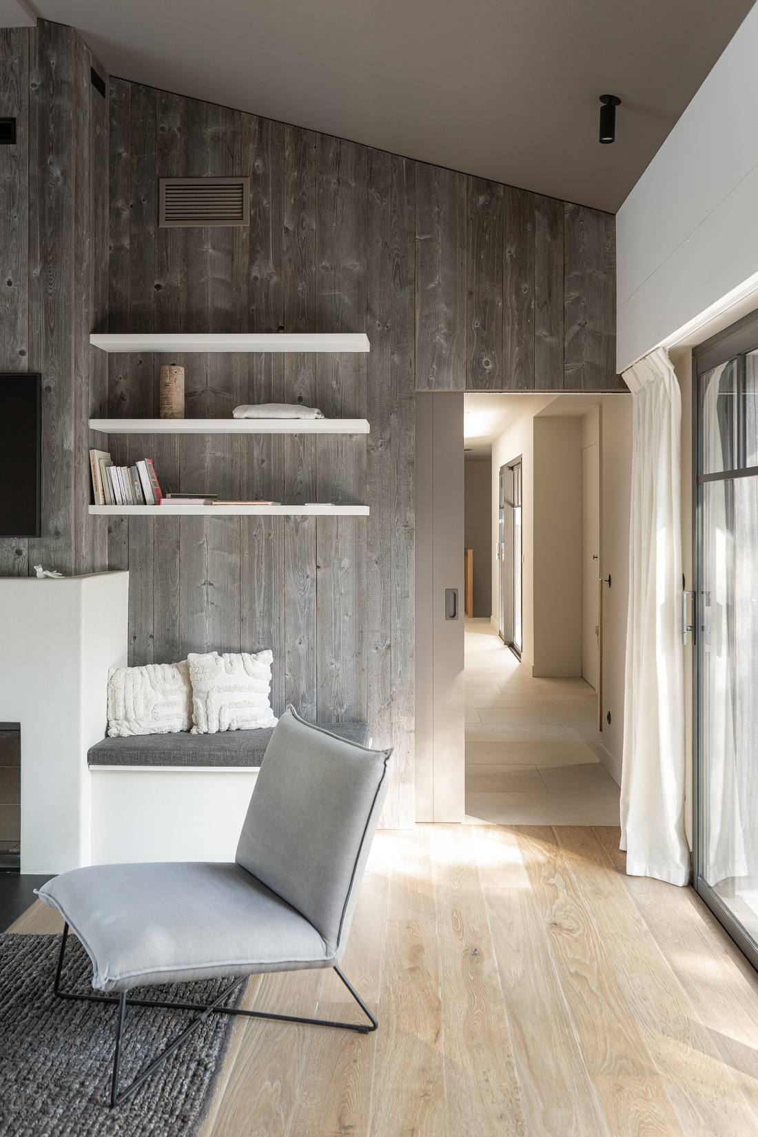 Couloir avec banquette, étagères et mur en bois grisé, aménagement intérieur en Gironde