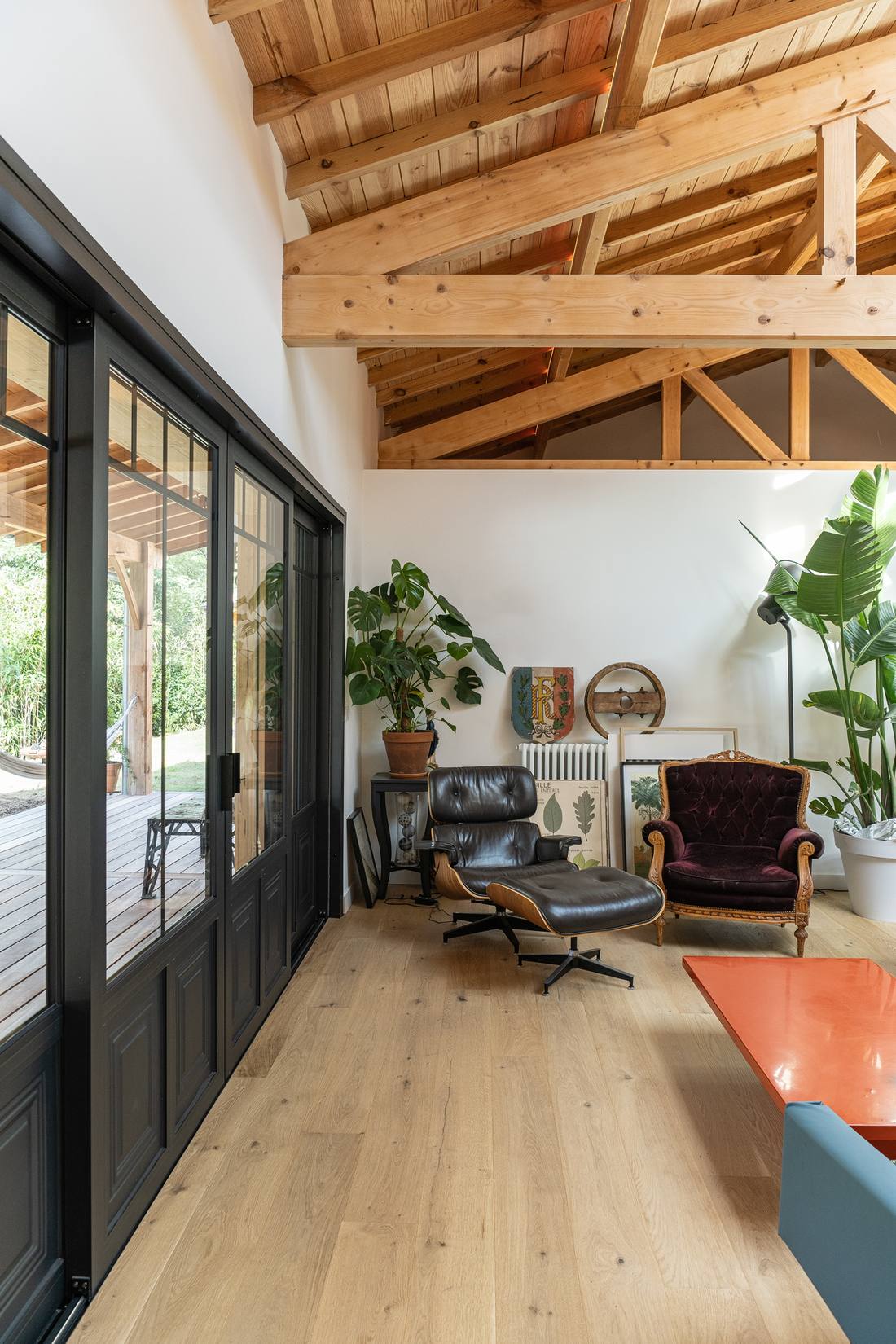 Salon contemporain sous charpente bois avec verrière noire, photographié par Maison Òstra sur le Bassin d'Arcachon